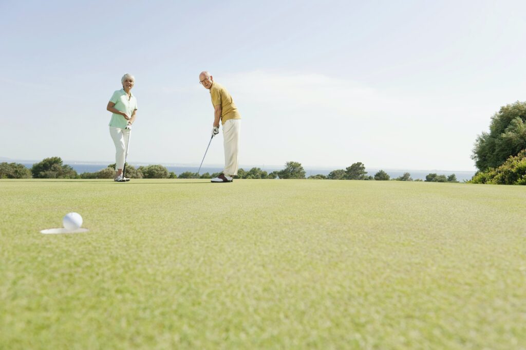 Spanien, Mallorca, älteres Paar beim Golfen auf einem Golfplatz
