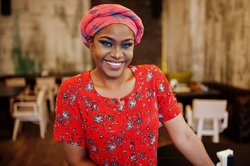 Stylish african woman in red shirt and hat