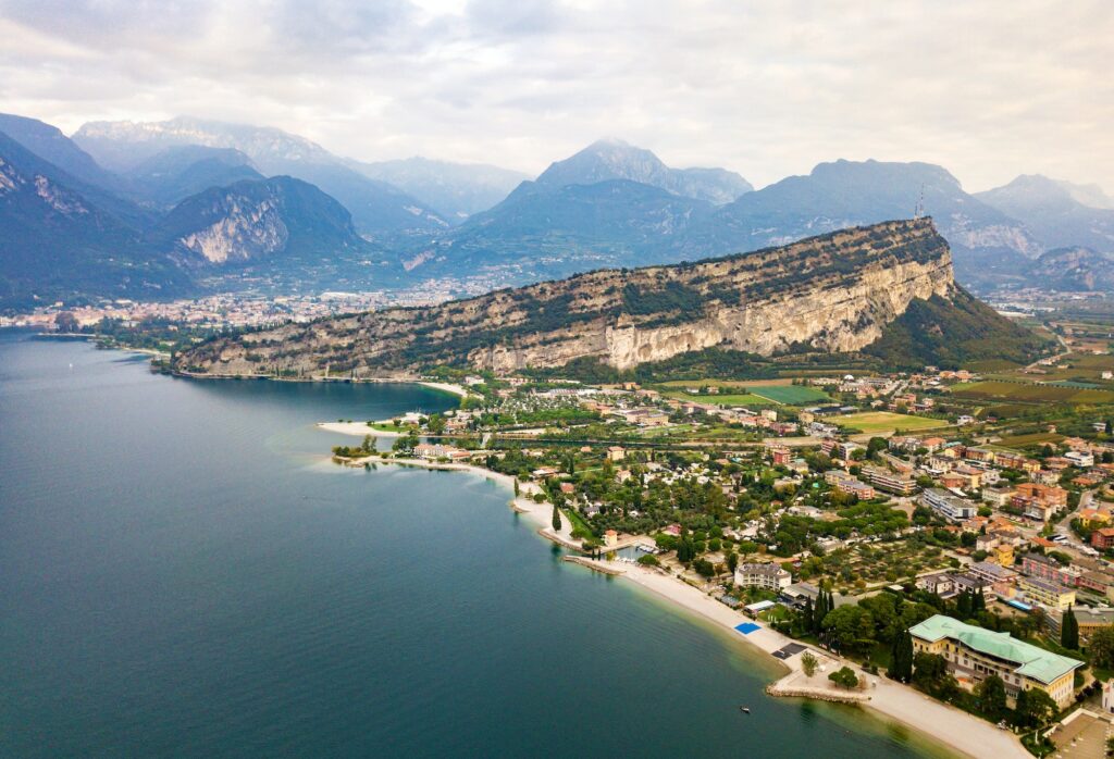 Blick von oben auf den Lago di Garda und das Dorf Torbole, alpine Kulisse. Italien