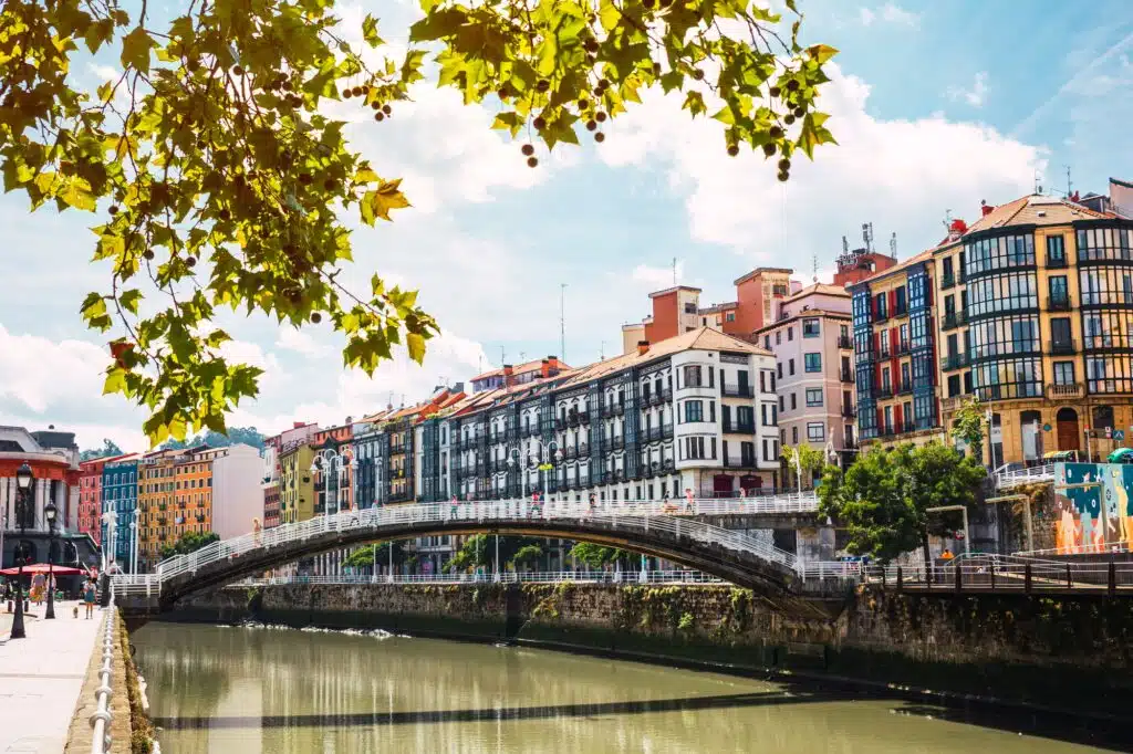Bilbao downtown with the Nervion river, Ribera bridge and its colorful architecture on a sunny day
